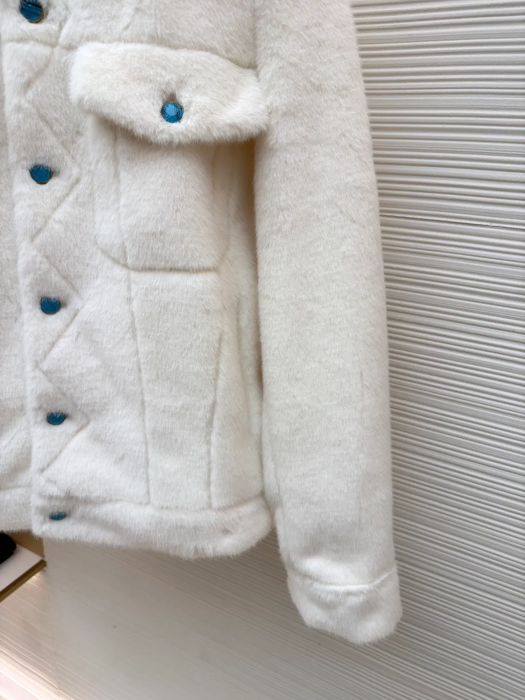LOUIS VUITTON Turquoise Mink Jacket ●Original version: Purchased and developed at 147799 ●Item number: 1681421-C30 ●Fabric: mink fur fabric ●Technology: embroidery production ●Color: white ●Version: Fitted version ●Weight: about 1065 grams ●Size: 46-48-50-52 ●Description: This jacket is made of high-end imitation mink velvet fabric, which is soft and fluffy to the touch and has excellent warmth retention. The lapel design adopts three-dimensional tailoring + precision sewing technology, and the collar shape is crisp and naturally connected with the body. The placket button is a custom-made blue-green metal button, which creates a visual contrast with the white fabric. It is sewn in precise position and opens and closes smoothly. The large pockets on both sides use three-dimensional bag-shaped technology, and the bag mouth echoes the buttons, combining practicality and design. The inner lining is made of the brand's classic pattern printed fabric, which is combined with the outer layer of plush fabric through laminating sewing technology to create a strong sense of layering. The overall cut is a loose-shouldered version, and the multi-piece structure is spliced ​​to create a casual and trendy wearing effect while ensuring comfort and freedom during movement. It is a fashionable item that combines luxurious plush texture with exquisite craftsmanship. The overall wiring is straight and delicate, the fabric is comfortable and soft, and the color is consistent without color difference. It can be matched with the same style to create a fashionable look and control various occasions. Customized accessories, complete with three standards, same style for men and women!